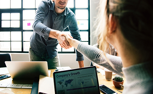 Two team members shaking hands during a meeting